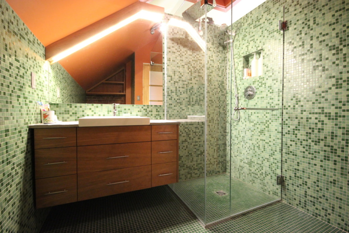 Bathroom with glass mosaic on walls and floor with curbless shower and wall hung vanity under the roof in Almonte by Renovation to Perfection.