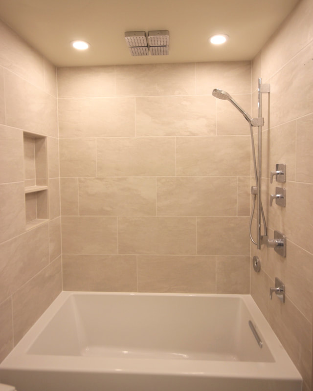 Tub surround with Hansgrohe shower set, movable ceiling shower tiles and spoutless Kohler tub filler in Ottawa by Renovation to Perfection.