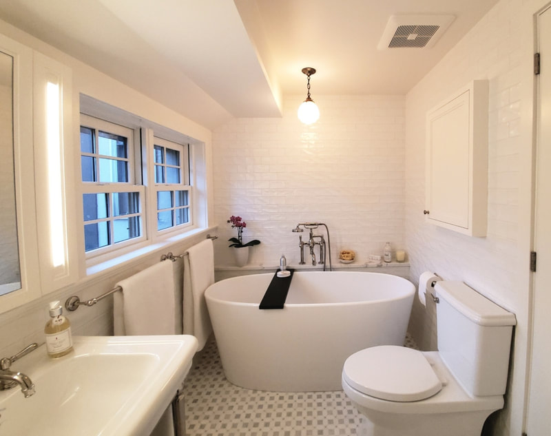 Ensuite bathroom with marble mosaic on the floor, 3D subway tiles on the walls, freestanding bathtub and custom cabinetry with incorporated LED lights in the mirror cabinet in Ottawa by Renovation to Perfection.