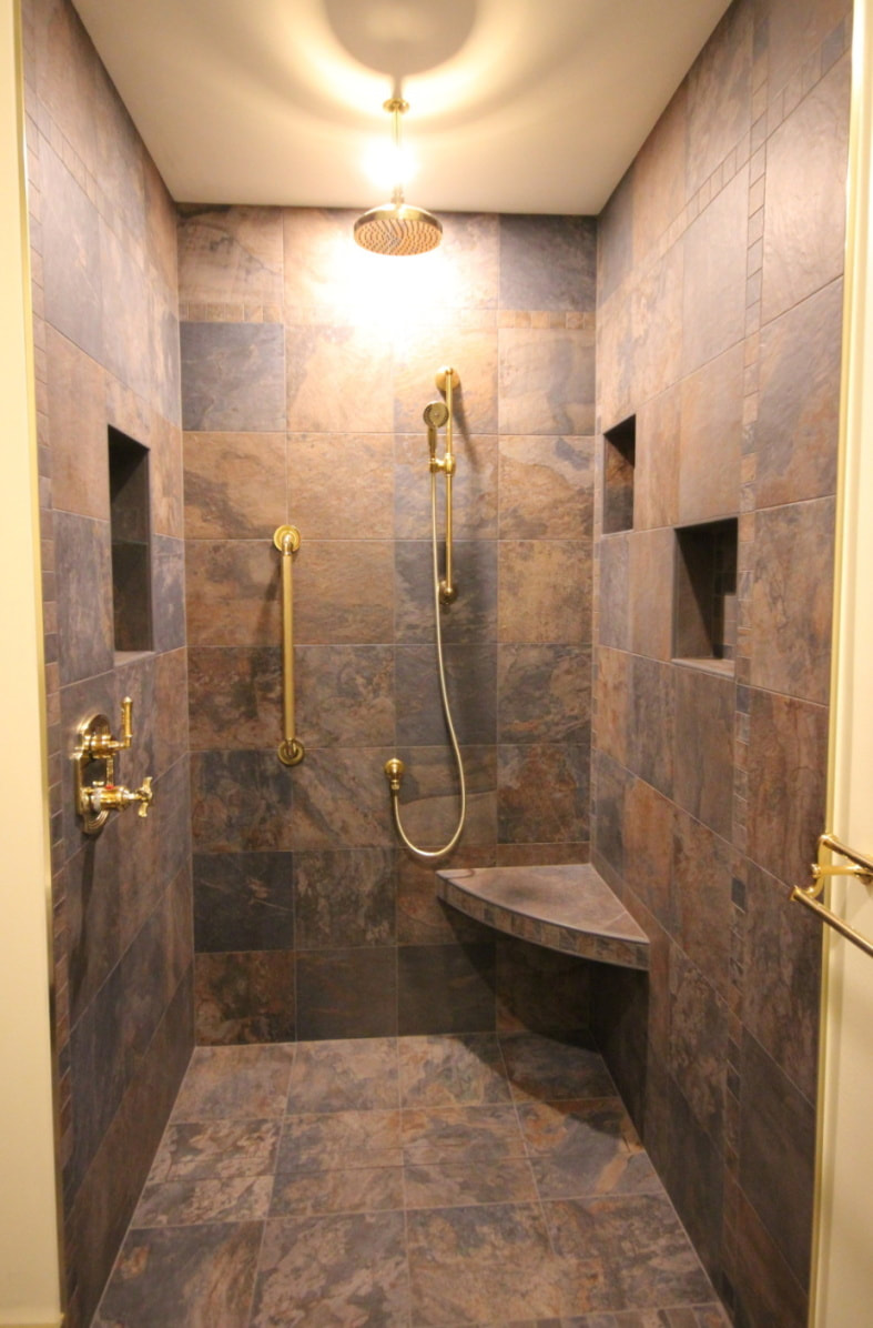 Custom bathroom with slate looking porcelain tile featuring linear drain shower with 3 niches and curved corner bench, brass fixtures in Pakenham by Renovation to Perfection.