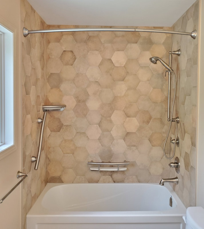 Tessalation bathroom - tub surround with hex tiles and corner shelf, shampoo shelf and accent bar Invisia grab bars in Almonte by Renovation to Perfection.