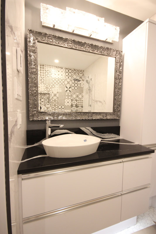 Custom vanity cabinet with integrated LED light on the underside of the cabinet, mirror in the picture frame. You can see the the shower accent wall in the mirror reflection, in Ottawa by Renovation to Perfection.